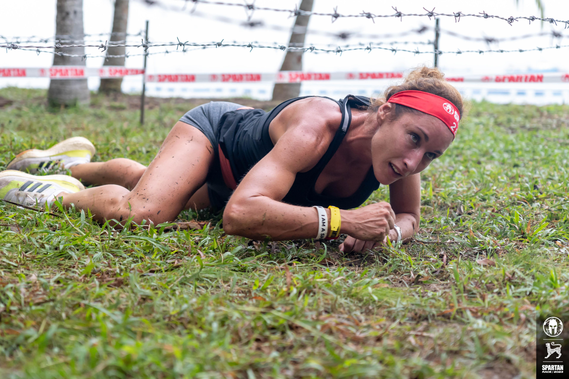 Melissa Sapmaz gateando bajo el alambre de espino en una carrera Spartan