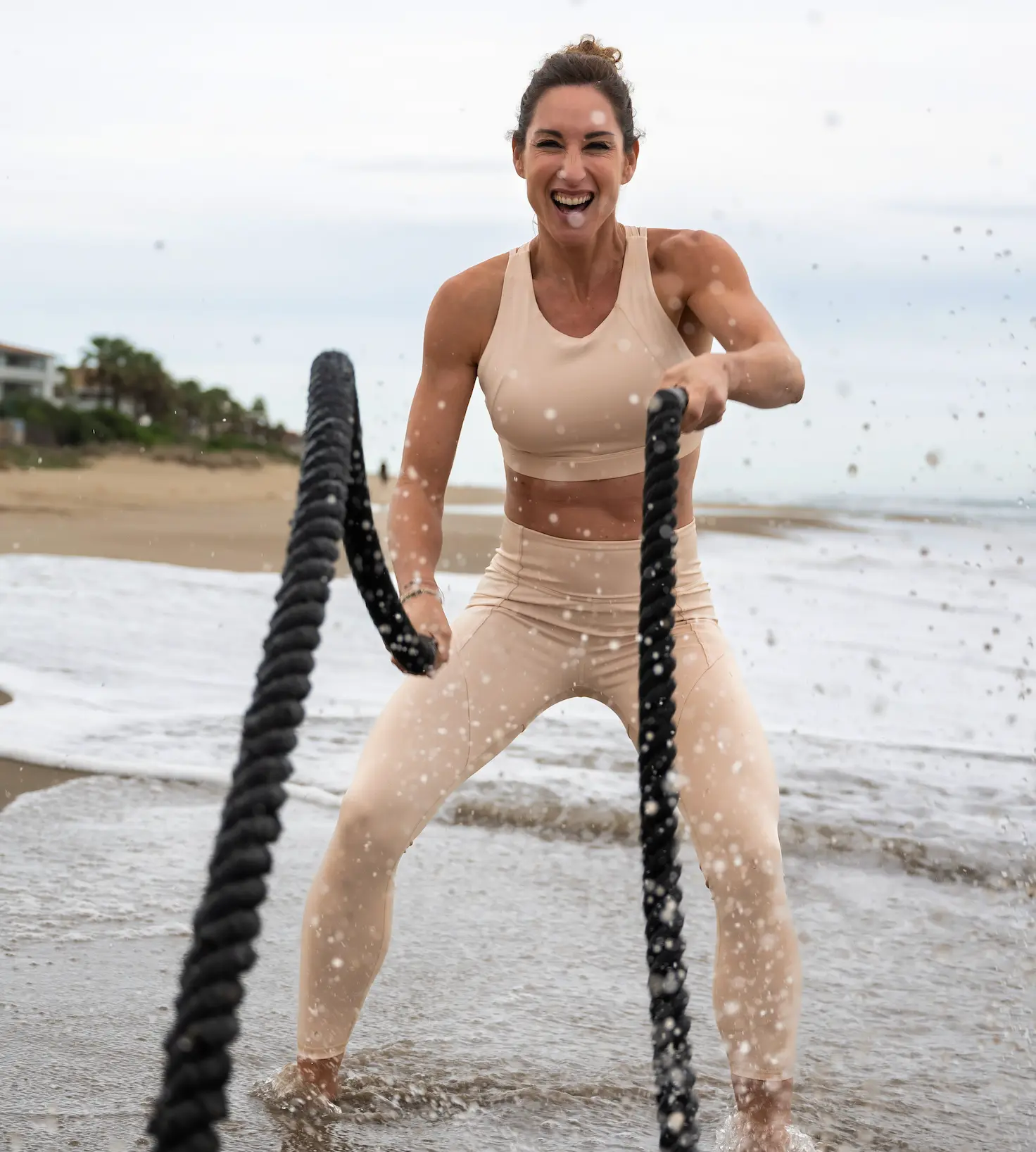 Melissa Sapmaz entrenando con cuerdas de batalla en la orilla