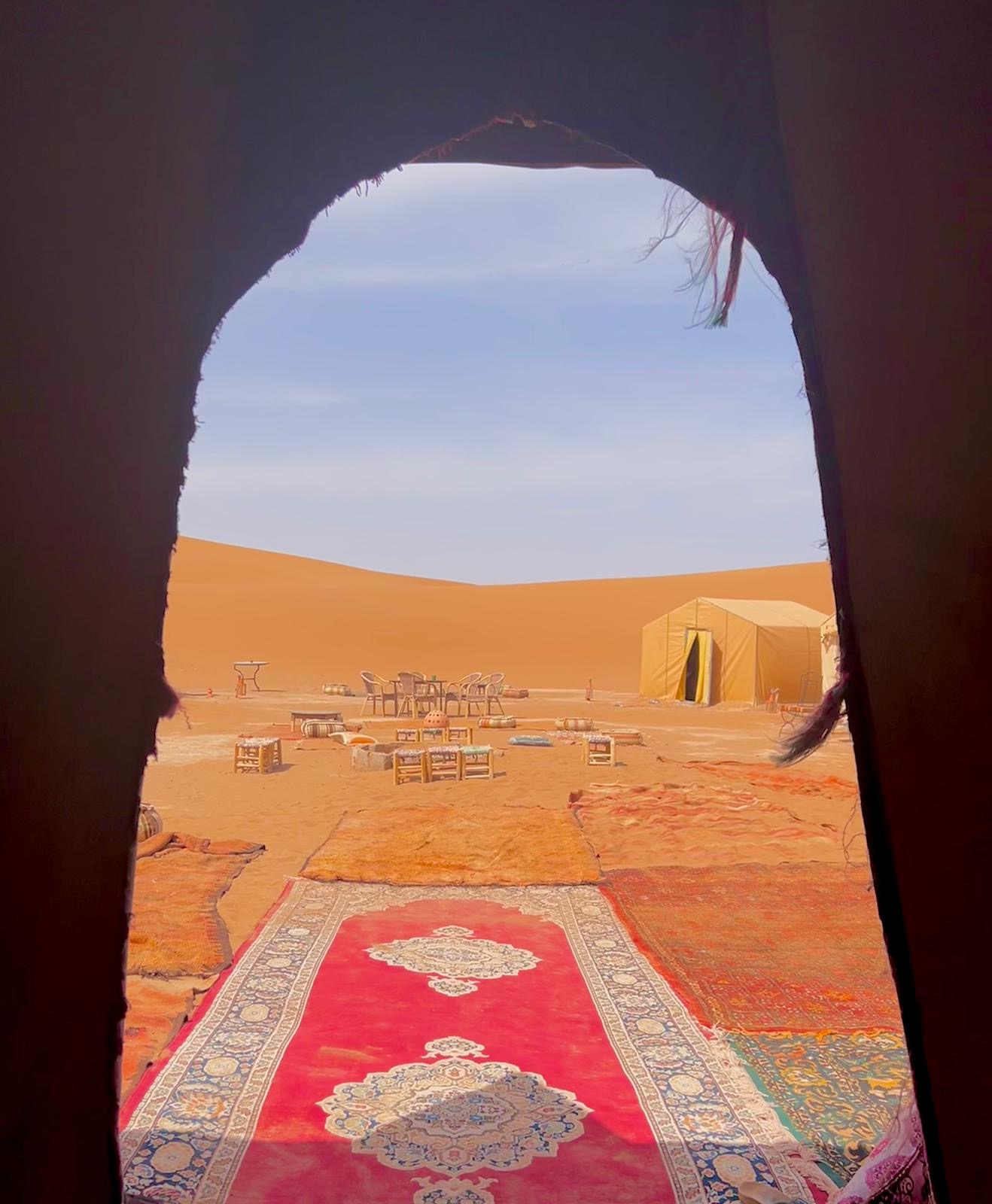 Vista desde el interior de una jaima hacia el campamento en las dunas del Sahara
