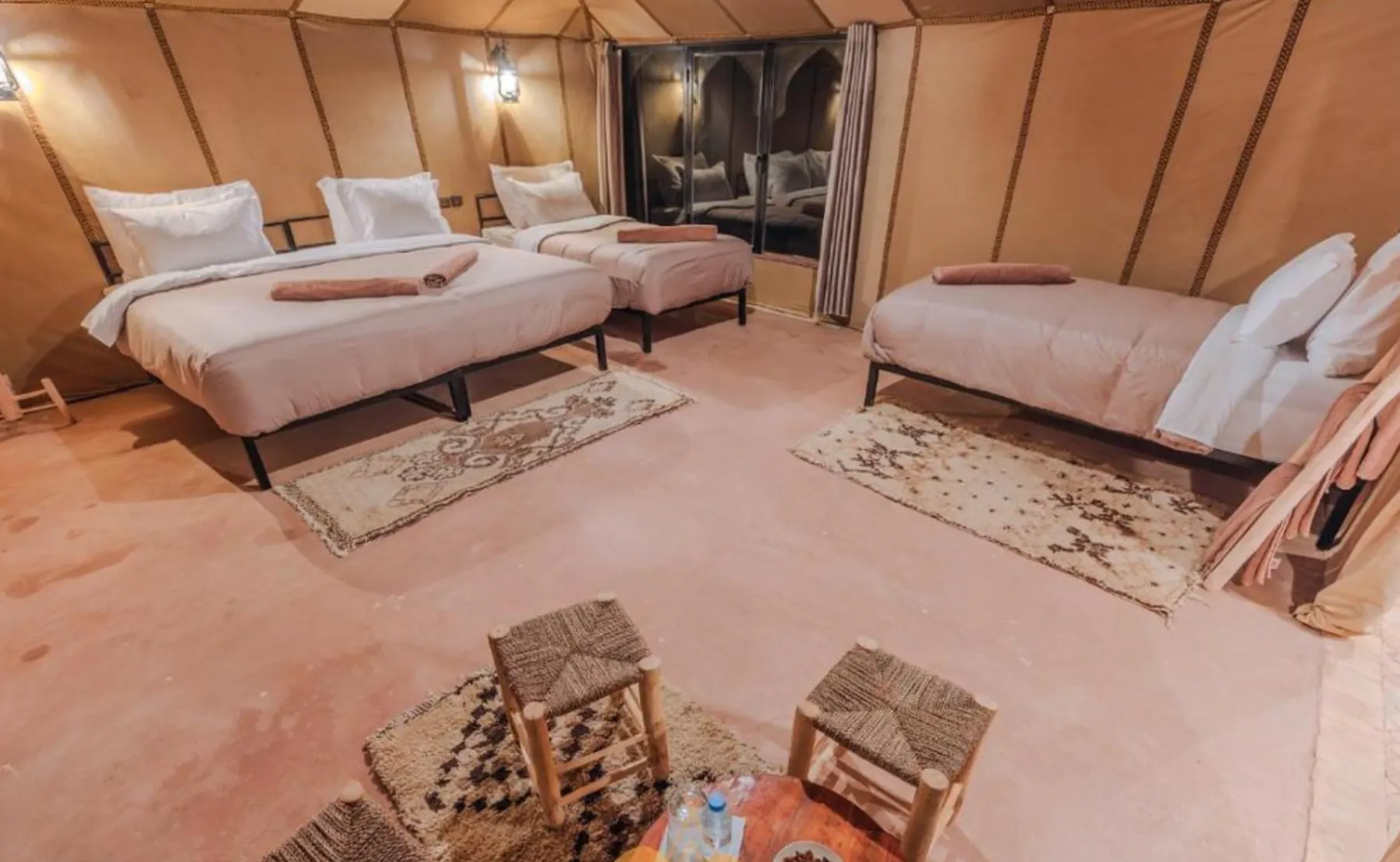Habitación en jaima con camas y alfombras bereberes